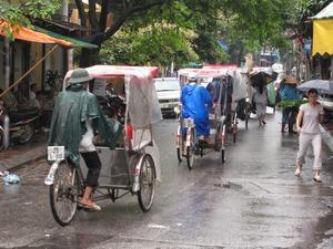 Cyclos In The Rainy Hanoi Streets