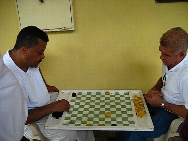Dominican amigos playing what appears to be a form of checkers