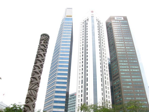 Totem pole next to skyscrapers