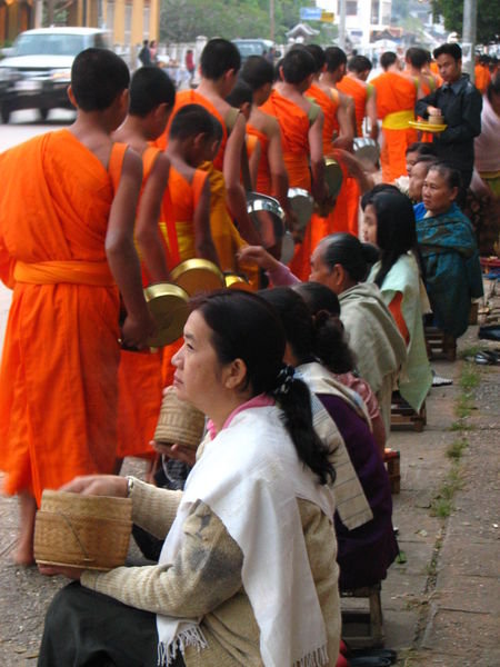 Locals giving alms to monks