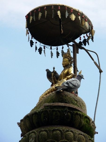 Hindu god with attendant pigeons at the Swoyambhu Temple, Kathmandu