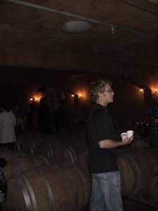 Fran in another part of the cellar with all the barrels of wine