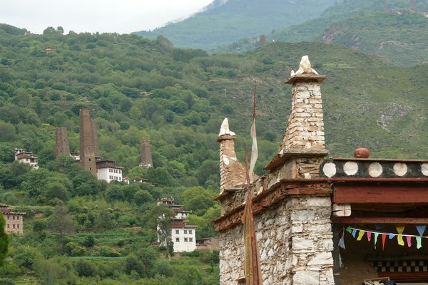 Jiarong house with ancient Qiang dynasty watchtowers behind