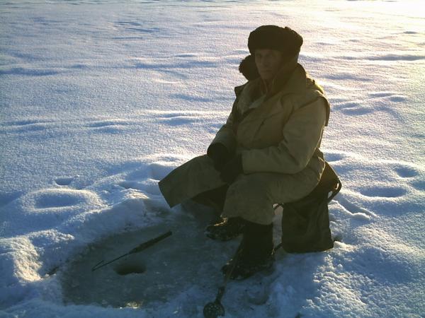 Aleksandr the ice fisherman and his ice fishing hole.
