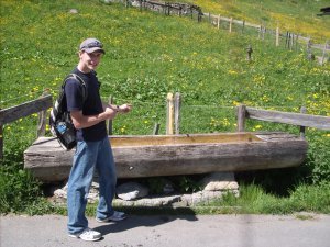 preston in front of another water trough in gimmelwald