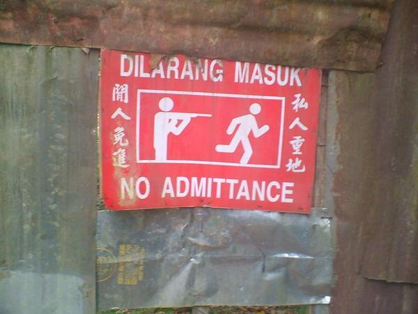sign on jungle trek- do not enter or i will shoot you in the head. hehe, a universally understood sign 