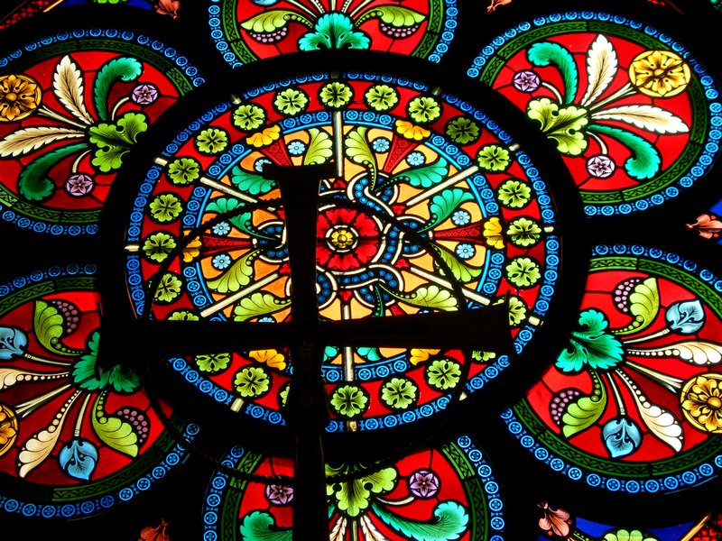 The cross in front of a round window.