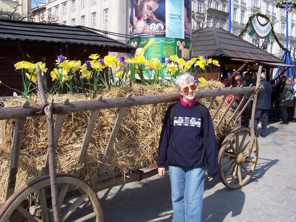 Nancy beside a flowered hay wagon.