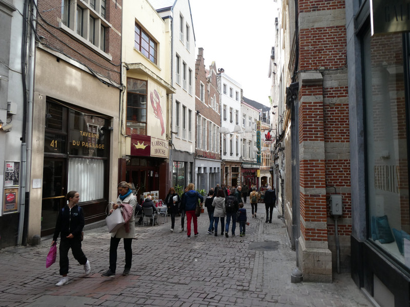 Typical cobblestone street with small businesses and cafes.
