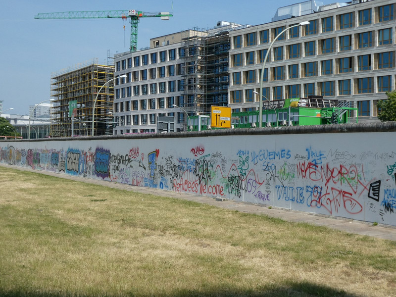 Stepping through the opening in the wall, the side facing the former East Berlin is heavily graffitied.