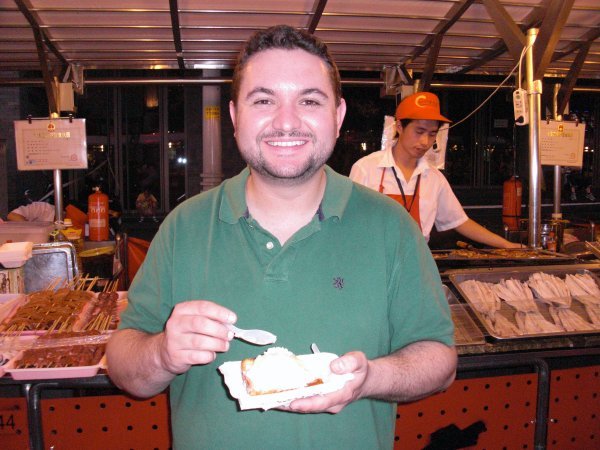 Peter eating "Deep Fried Icecream" at the Donghuamen Night Market. 