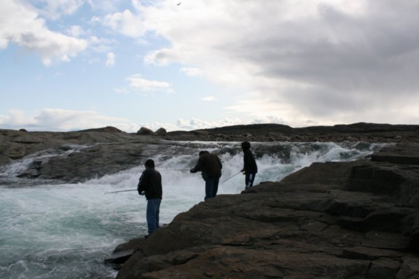 3 inuit fishing in front of the falls
