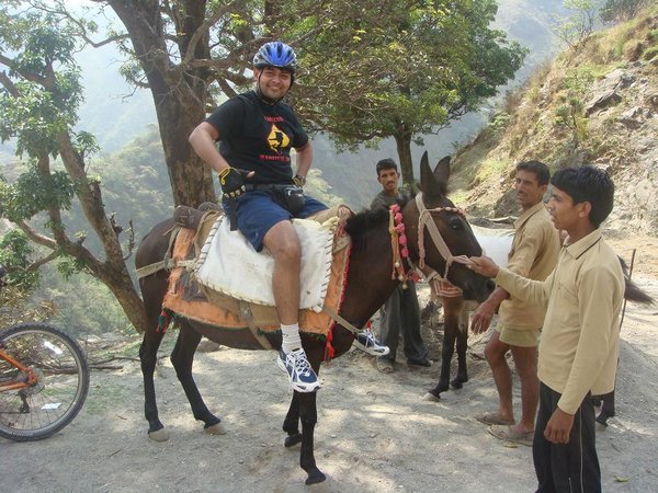 the dude is practising for his marriage when he will have to ride a horse but definitely not in biking gears