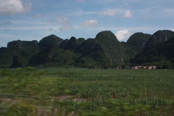 China to Vietnam By Bus - Village Nestled Into Base of Hills