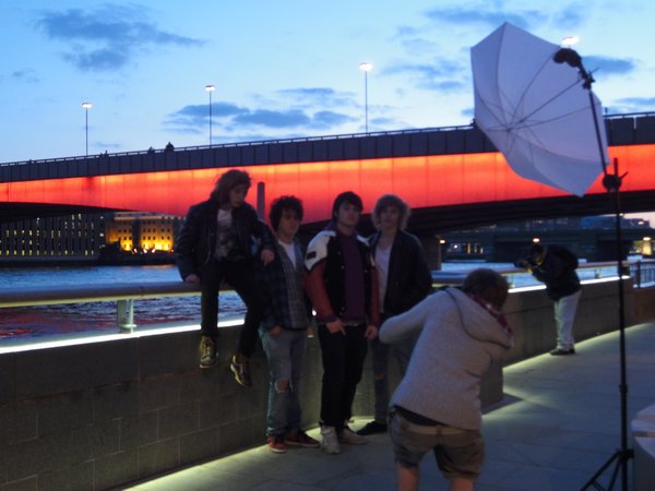 A photo shoot in front of a lit London Bridge