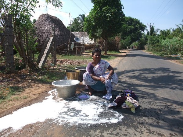 Lady washing at the side of the road