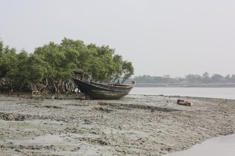 An old boat lies abandoned on a mud flat