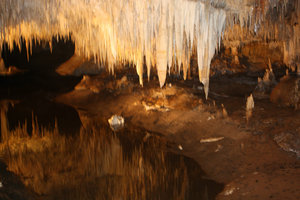 The stalactites are reflected in the water