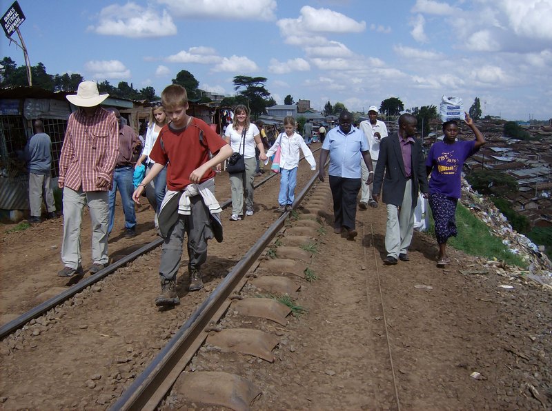 Sue Sandford family walks along railway line by passing the Kibera Slums 