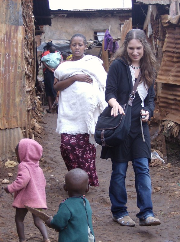 A Volunteer escorts a mother in kibera slums