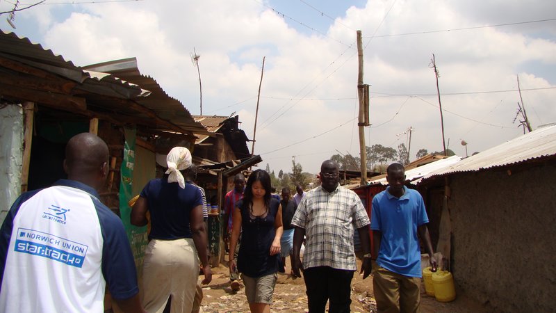A solo lady escorted while visiting Kibera slums