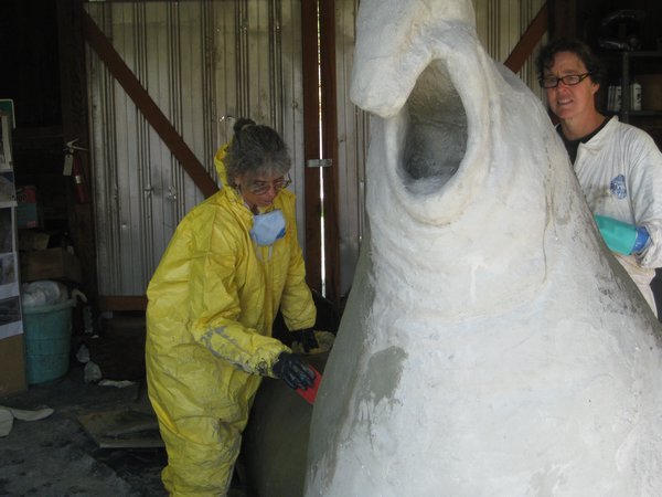 Meisse and Ali apply stucco to the elephant seal sculpture