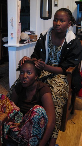 Sadio braiding Fatoumata's hair