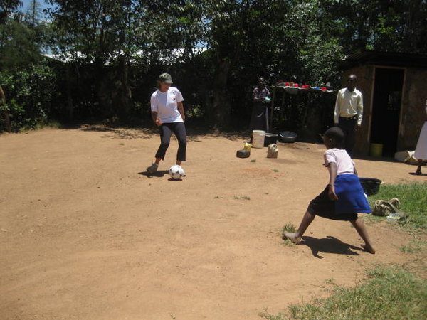 Karen playing soccer with children at Inkonyero