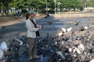 Eva feeding pigeons in the Central Plaza in Guatemala City