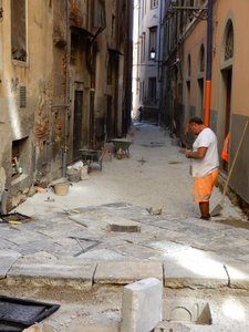 Hard at Work Laying Down a Stone Alleyway