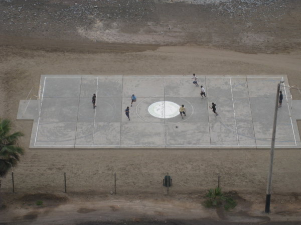 Drenge der spiller fodbold ved stranden