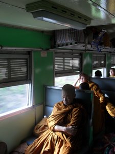 A monk snoozing on the train