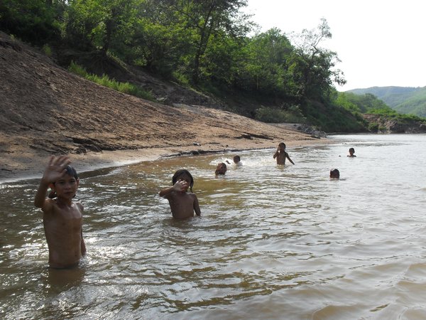 Children waving in river