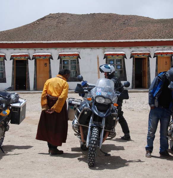 a quick bike inspection by the local monk before we're allowed into our homestay accomodation in the background