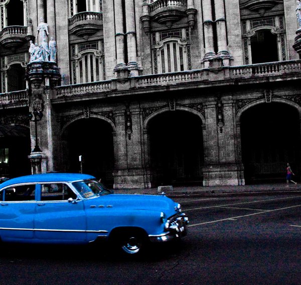A classic car passing the Teatro Nacional