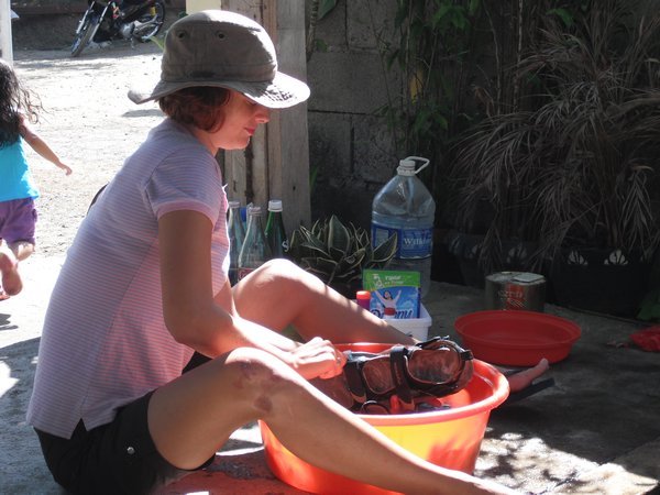 Oriel washes sandals which are still smelly after our stay at Nuts Huts