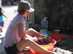 Oriel washes sandals which are still smelly after our stay at Nuts Huts