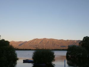 Reddening mountains across lake McGregor