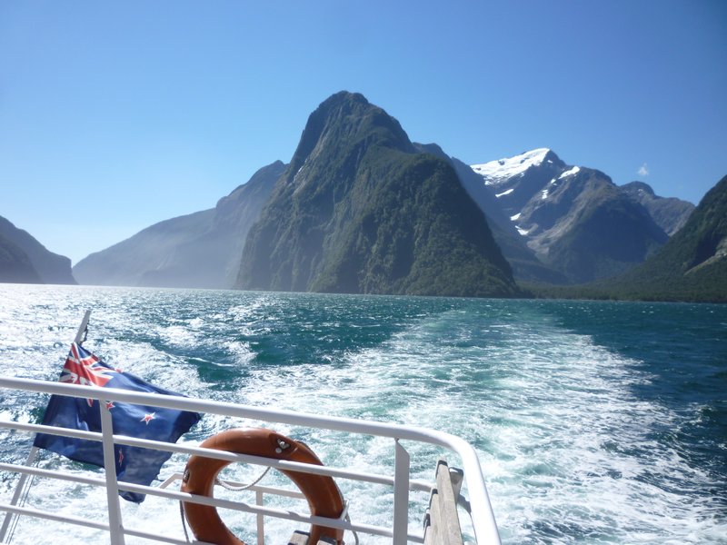 New Zealand flag with her stunning fiordland behind