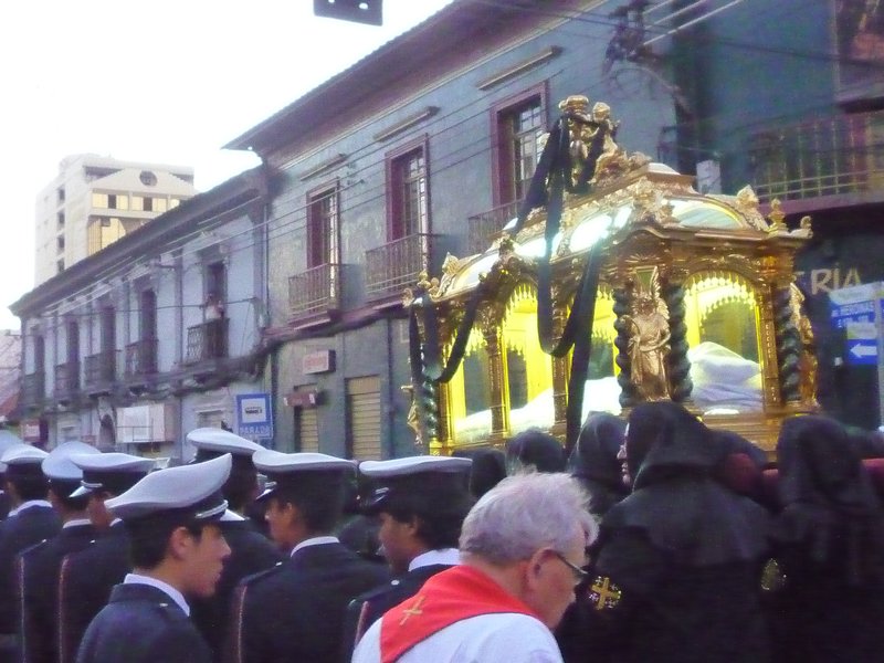Military officers flank the gold coffin with crist statue inside