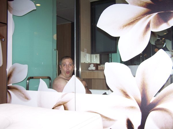 Rick in Singapore hotel bathtub with glass partion