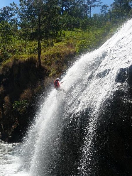 Rachel rappelling down a waterfall