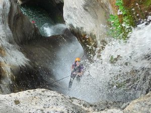 Rachel canyoning down a waterfall