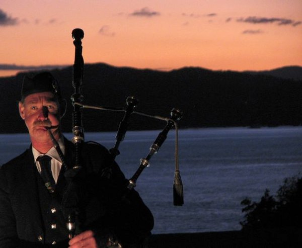Bagpiper playing at end of service with sunrise.