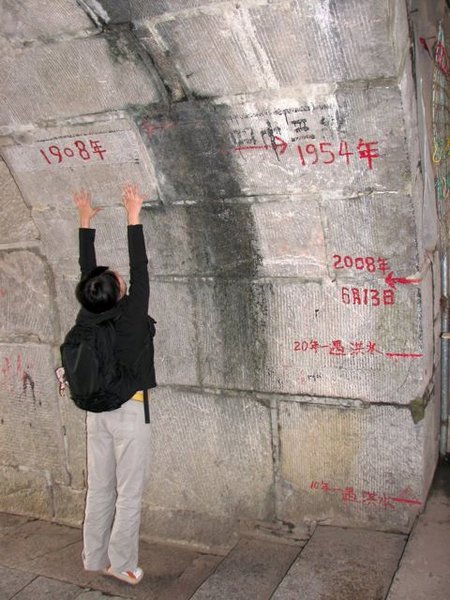 Ling trying to reach the flood line of 1908 in Yangshuo.