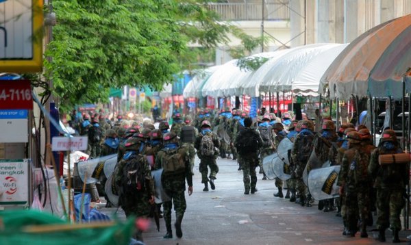 Soldiers march past miles of makeshift shelters