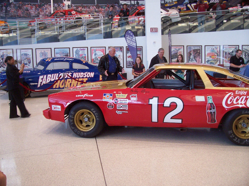 Bobby Allison Looks Over The Replica Of His 1973 Chevrolet – Note Glory Road In The Distant Background Above The Wall Of Posters