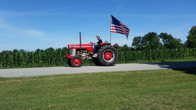 A Tractor And An American Flag With A Cornfield As A Backdrop!