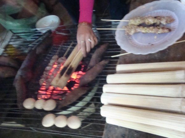 Grilling up some pork, eggs, sweet potato and rice in bamboosticks