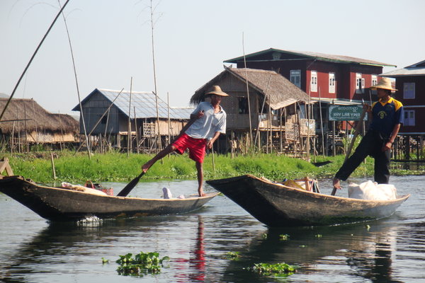 Two fishermen rowing out of their village